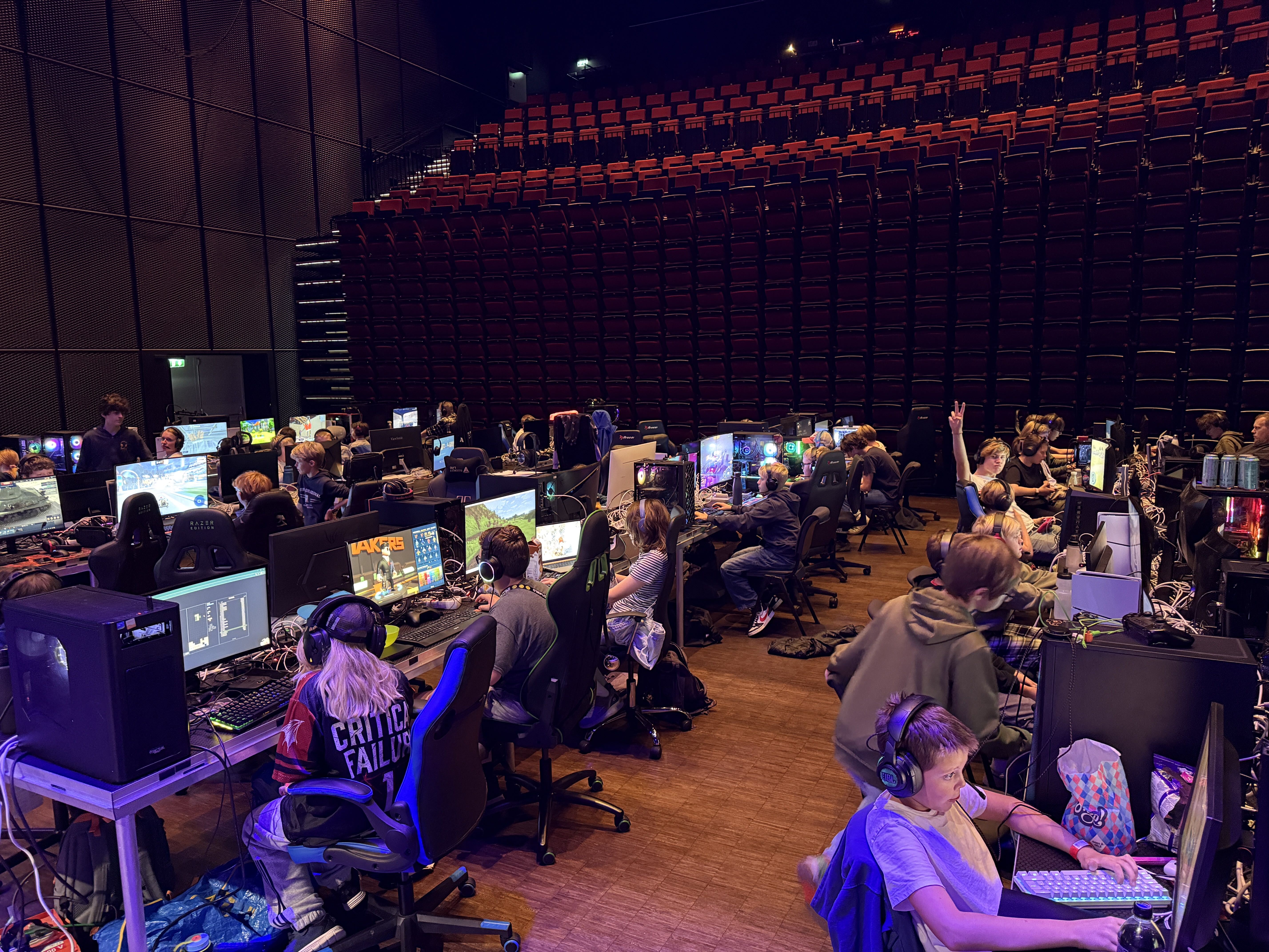 Oversikt over LAN-området i Kongsberg Musikkteater med rekker av gamingplasser under LEVEL UP LAN Kongsberg